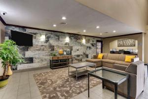 - un salon avec un canapé et une télévision dans l'établissement Best Western PLUS University Inn & Suites, à Wichita Falls