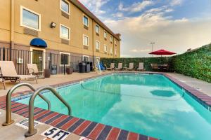 una piscina en un hotel con sillas y mesas en Best Western PLUS University Inn & Suites, en Wichita Falls