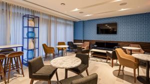 a waiting room with tables and chairs and a couch at Best Western Premier Empire State Hotel in New York