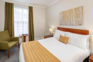 a hotel room with a bed and a chair at New Continental Hotel; Sure Hotel Collection by Best Western in Plymouth