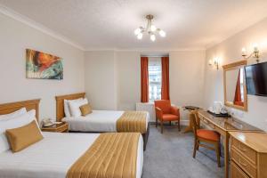 a hotel room with two beds and a desk at New Continental Hotel; Sure Hotel Collection by Best Western in Plymouth +64 photos