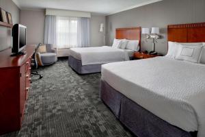 a hotel room with two beds and a flat screen tv at Sonesta Select Tinton Falls Eatontown in Tinton Falls