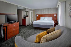 um quarto de hotel com uma cama e uma televisão em Sonesta Select Tinton Falls Eatontown em Tinton Falls