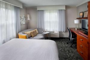 a hotel room with a bedroom with a bed and a desk at Sonesta Select Tinton Falls Eatontown in Tinton Falls