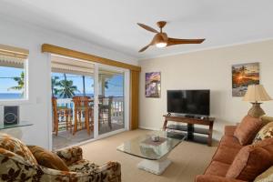 a living room with a couch and a flat screen tv at Ocean View 2 Bedroom Kahalu'u Reef in Kailua-Kona