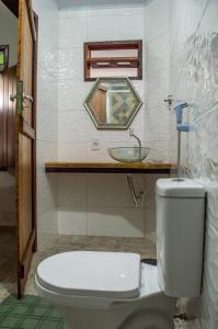 a bathroom with a toilet and a sink at Marezal Suítes in Pôrto de Pedras