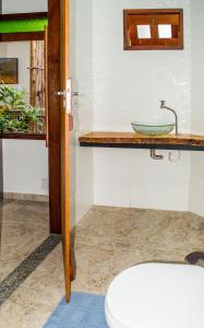 a bathroom with a sink and a toilet at Marezal Suítes in Pôrto de Pedras