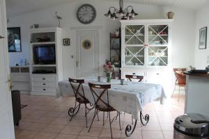 comedor con mesa y reloj en la pared en Casa breti, en Bretignolles-sur-Mer