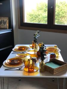 貢多馬爾的住宿－Pedra Moura Casa Rural，一张带盘子和玻璃杯的白色桌子