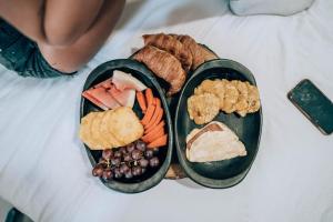 deux assiettes avec différents types de nourriture sur un lit dans l'établissement Neos Hotel Cartagena, à Carthagène des Indes