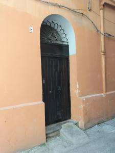 una puerta negra en el lateral de un edificio en Afrodite appartamento Ballarò, en Palermo