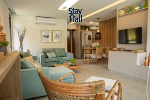 sala de estar con sofá azul y TV en Bangalô Luxo-3QT-Jacuzzi e Piscina Privativa-SH009 en Praia dos Carneiros