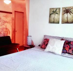 a bedroom with a bed with a white blanket and palm trees at Cabinas Flamingo in Playa Flamingo