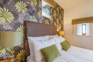 sypialnia z łóżkiem i ścianą z kwiatami w obiekcie Stables Cottage w mieście Llanrwst