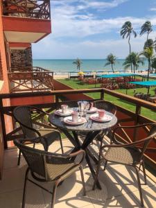 d'une table et de chaises sur un balcon avec vue sur la plage. dans l'établissement Kariri Beach - 207 - Praia do Cumbuco, Caucaia, à Cumbuco
