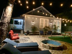 a patio with a fire pit and a house at night at Pershing Place: Historic home with heated spa/pool by Zoo, Pearl, Golf, Witte in San Antonio +52 photos