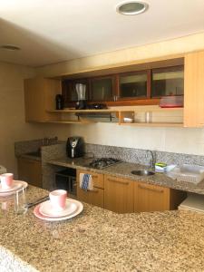 a kitchen with a counter with two plates on it at Kariri Beach - 207 - Praia do Cumbuco, Caucaia in Cumbuco +13 photos