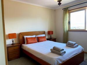 ein Schlafzimmer mit einem Bett mit Handtüchern darauf in der Unterkunft Xavega Apartment in Torreira
