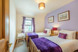a bedroom with two beds and a window at Dairy Cottage in Llanrwst