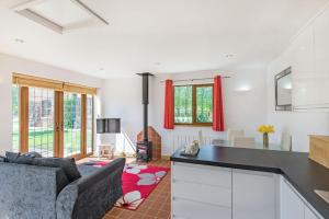 a kitchen and living room with red curtains at Garden Cottage in Spilsby