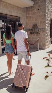 Ein Mann und eine Frau gehen mit einem Koffer in der Unterkunft Boutique Hotel Momentum by Aycon in Budva