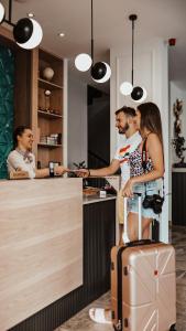 a group of people standing around a kitchen with a counter at Boutique Hotel Momentum by Aycon in Budva