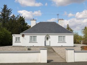 a white house with a gray roof at Carnmore Cottage in Dungloe