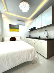 胡志明市的住宿－My Hotel，白色卧室设有床铺和水槽