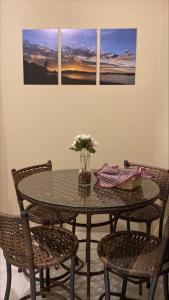 una mesa con sillas y un jarrón con flores. en Pousada Carolina, en Penha