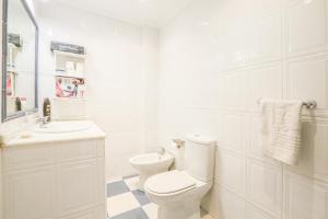 ein weißes Badezimmer mit Toilette und Waschbecken in der Unterkunft JUDERIA CENTER PREMIUM SUITES FREE Parking in Sevilla + 16 Fotos