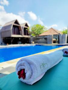 a towel sitting on a table near a swimming pool at The Bali Menjangan Boutique Villas & Dive Center in Pemuteran