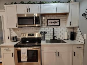 a kitchen with white cabinets and a stove and a sink at Just Dance in Dandridge