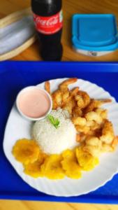 um prato de comida com camarão e arroz numa mesa em Hostal LAS GARZAS DEL PELADO em Playas