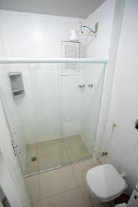 uma casa de banho com uma cabina de duche em vidro e um WC. em PRAIA DO MORRO - APTO 3 QUARTOS SENDO 2 SUITES WIFI 300 MB E GARAGEM - 50 METROS da PRAIA - ATÉ 8 PESSOAS em Guarapari
