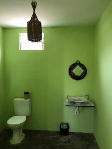 Baño verde con aseo y espejo en Mar Aberto_chale 3 en Barroquinha