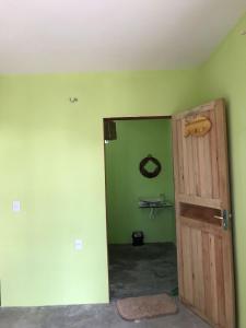 an empty room with a door and a green wall at Mar Aberto_chale 3 in Barroquinha