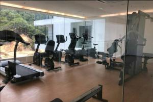 Un gimnasio con cintas de correr y elípticas en una habitación. en Aeropod [5B]/Near Airport / 2 Queen Bed/ Netflix/Free Parking, en Kota Kinabalu 11 fotos más
