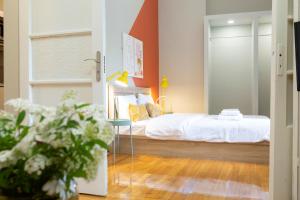 a bedroom with a bed with white sheets and orange walls at Acropolis Apartments in Athens