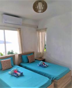 2 camas en una habitación con sábanas azules en Seychelles Yellow Petals, en Anse Boileau