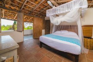 a bedroom with a bed with a canopy at Casa de la Gente Nube in Puerto Escondido