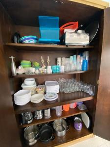 a shelf with plates and cups and other dishes at Cómoda Casa Finca con Piscina - San Jerónimo, Ant in Medellín