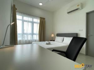 a bedroom with a bed and a desk with a chair at Mesa Hill Nilai by Beestay Management in Nilai