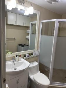 a bathroom with a toilet and a sink and a shower at Spacious 2 Bedroom condo unit for rent in Iloilo City