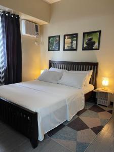 a bedroom with a large bed with white sheets at Spacious 2 Bedroom condo unit for rent in Iloilo City
