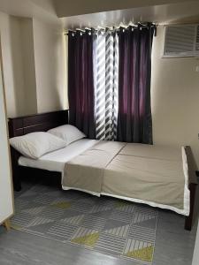 two beds in a room with a window at Spacious 2 Bedroom condo unit for rent in Iloilo City