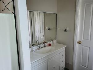 a bathroom with a sink and a large mirror at The Junction Estate COOL CALM COZY A Home N Host Property in Wallerawang