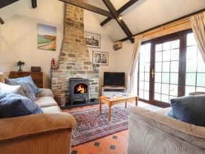 a living room with a couch and a fireplace at Bwthyn Alarch in Haverfordwest