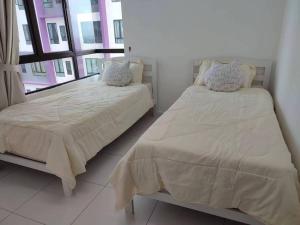 a bedroom with two beds and a window at Cozy Condo at Melaka Top Hill, 7-9pax in Ayer Keroh