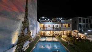 a building with a swimming pool and the eiffel tower at 8 Flags Resort Laguna in Los Baños