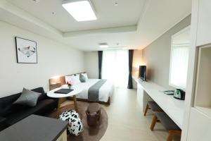 a hotel room with a bed and a couch at Geoje Leein Stay Hotel in Geoje